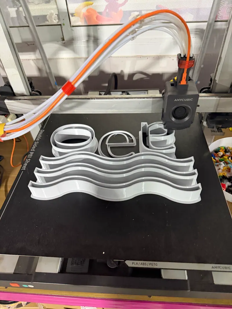 White sign part being printed on a 3D printer bed