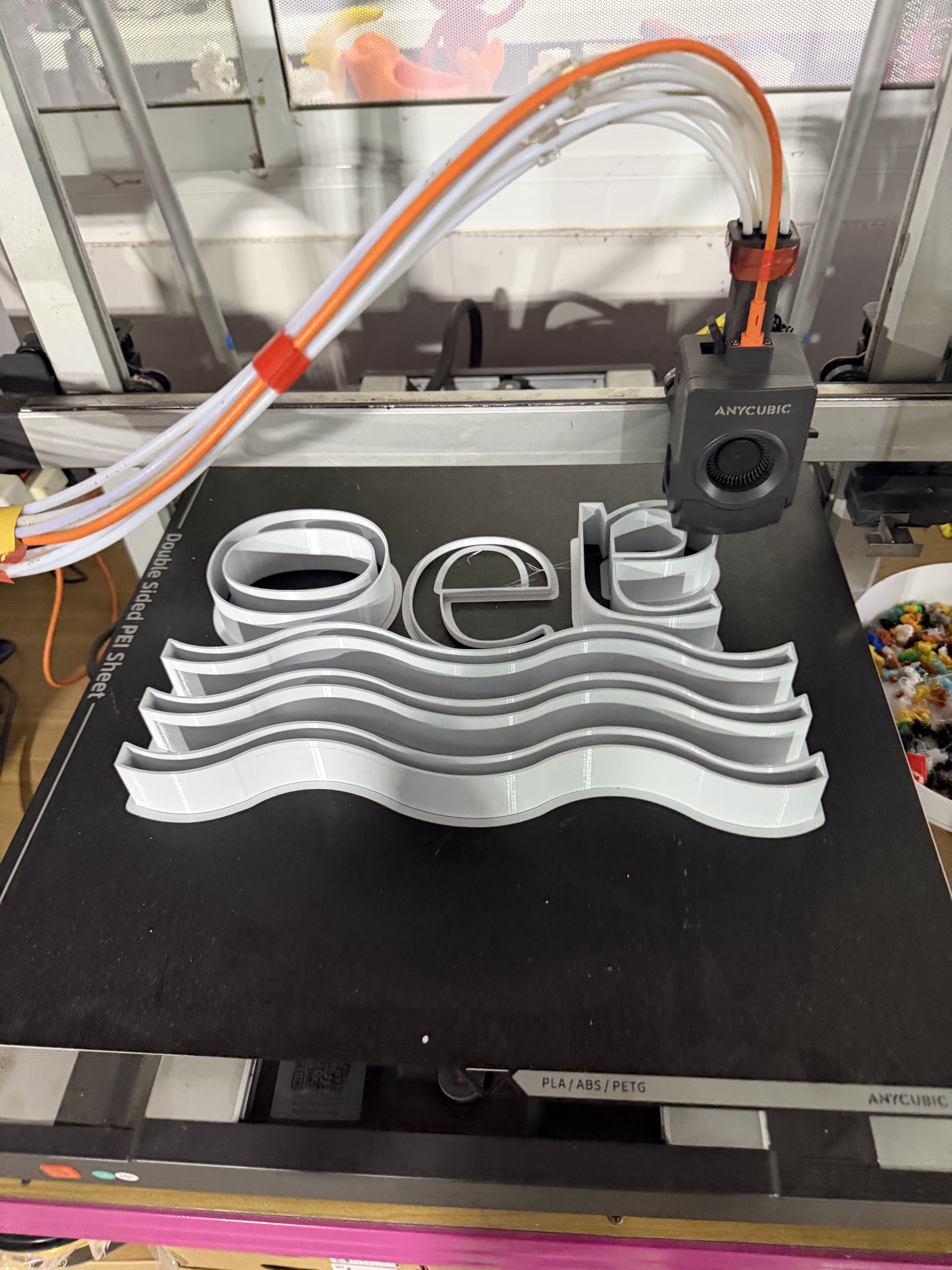 White sign part being printed on a 3D printer bed